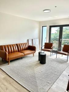 a living room with a brown couch and a rug at Luxury Furnished Apartment in Heart of Quincy in Quincy