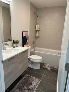 a bathroom with a toilet and a sink and a tub at Luxury Furnished Apartment in Heart of Quincy in Quincy
