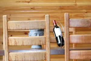 um par de cadeiras de madeira com uma garrafa de vinho em Cabana Energia em Pirenópolis em Pirenópolis