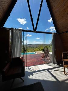 uma vista para uma sala de estar com uma grande janela em Cabana Energia em Pirenópolis em Pirenópolis