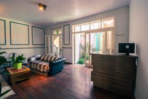 uma sala de estar com um sofá e uma televisão em Pelotas Bier Hostel em Pelotas