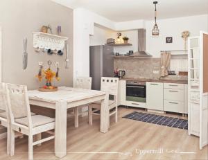 a kitchen with a table and chairs in a room at Uppermill Suite #3 in Pécs