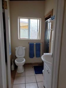 a bathroom with a toilet and a sink and a window at CASA MARBELLA 4BR 2BA Private Beach-Front Home in Ensenada