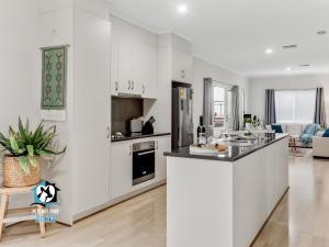 cocina con armarios blancos y encimera en 3BR Contemporary Home with Sea Views, en Victor Harbor