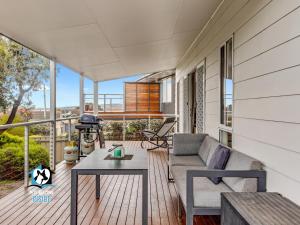 porche con sofá y mesa en el balcón en 3BR Contemporary Home with Sea Views, en Victor Harbor