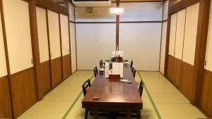 Jomon no Yado Manten في ياكوشيما: قاعة المؤتمرات مع طاولة وكراسي خشبية طويلة