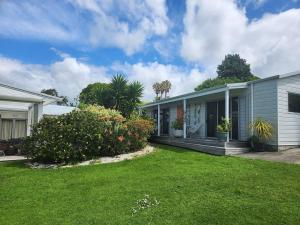 a house with a lawn in front of it at Hahei Getaway Tahi in Hahei