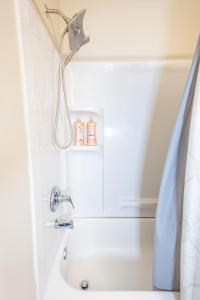 bañera con cabezal de ducha y lavamanos en LUX - Downtown Oasis - Pool Table! Free Parking!, en Lexington