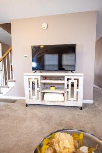 a flat screen tv on a white entertainment center at LUX - Downtown Oasis - Pool Table! Free Parking! in Lexington