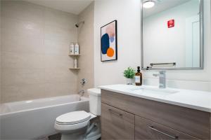 a bathroom with a toilet and a sink and a tub at Modern Furnished Apartment in Heart of Quincy in Quincy