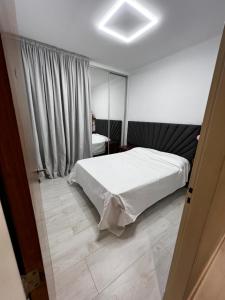 ein Schlafzimmer mit einem weißen Bett und einem Fenster in der Unterkunft Casa con pileta y garaje in Presidencia Roque Sáenz Peña