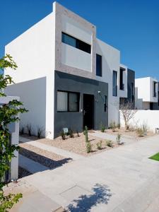 une maison blanche avec des fenêtres noires et une allée. dans l'établissement Casa Valtierra, La Paz, à La Paz