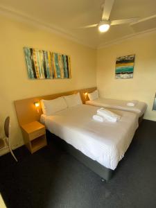 dwa łóżka w pokoju z dwoma oświetleniami w obiekcie Maitland City Motel w mieście Maitland