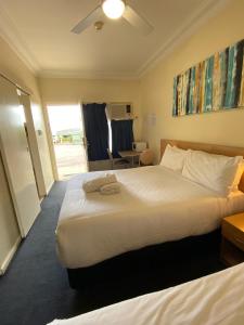 una camera d'albergo con un grande letto e un tavolo di Maitland City Motel a Maitland