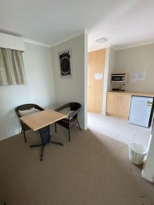 een kamer met een tafel en stoelen en een schoolbord bij Maitland City Motel in Maitland