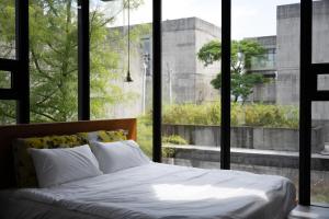 ein Bett in einem Schlafzimmer mit einem großen Fenster in der Unterkunft 宜蘭可以包棟別墅 l 寵物友善 l 烤肉 in Dongshan