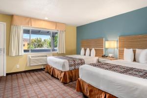 a hotel room with two beds and a window at Avenue Inn Downtown San Luis Obispo in San Luis Obispo