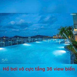 duży basen z niebieską wodą w nocy w obiekcie Homestay the Sóng w mieście Vung Tau