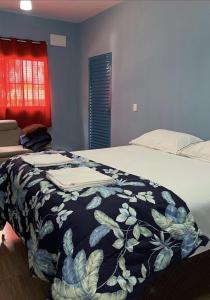 um quarto com uma cama com um cobertor em Pousada Dos Ypês em Artur Nogueira
