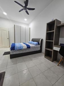 1 dormitorio con 1 cama y ventilador de techo en TSK Homestay Taman Sri Kluang, en Keluang