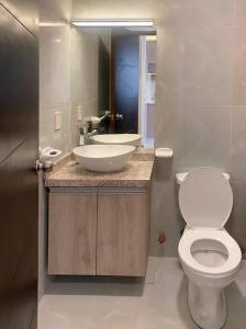 La salle de bains est pourvue de toilettes blanches et d'un lavabo. dans l'établissement EL OLMO, à La Paz