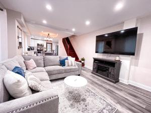 uma sala de estar com um sofá e uma televisão de ecrã plano em Cheerful & Modern Home w/ a Walkout Deck Area em Glenside