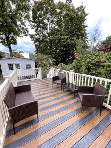 una terraza de madera con bancos y sillas. en Cheerful & Modern Home w/ a Walkout Deck Area, en Glenside