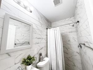 a white bathroom with a shower and a sink at Cheerful & Modern Home w/ a Walkout Deck Area in Glenside