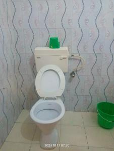 a bathroom with a toilet with a green box on top of it at Hotel Butterfly , Sauraha , Chitwan in Sauraha