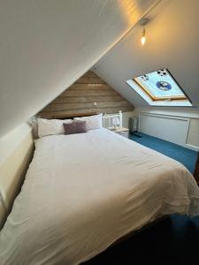 una camera da letto con un grande letto bianco in mansarda di Shared House in Chakeshill Drive a Bristol