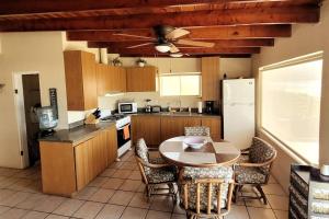 cocina con mesa, sillas y nevera en CASA MARBELLA 2BR 1BA Private Beach-Front Home, en Cabo Punta Banda