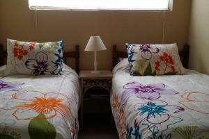 1 dormitorio con 2 camas y mesa con lámpara en CASA MARBELLA 2BR 1BA Private Beach-Front Home, en Cabo Punta Banda