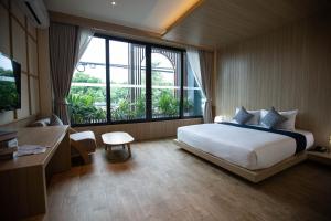 a hotel room with a bed and a large window at The Arch Phuket Hotel in Ban Ket Ho