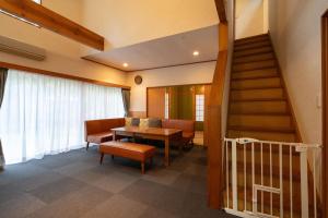 Una sala de estar con una escalera y una mesa y sillas. en S-villa Nasu 5th, en Nasu