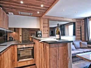 a kitchen with a bottle of wine on a counter at Duplex confortable avec conciergerie à Méribel - FR-1-613-9 in Méribel