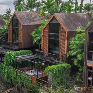 a house with a hot tub in the garden at DAMNERNPAWA in Bang Khon Thi