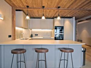 kuchnia z blatem z stołkami wokół niego w obiekcie Appartement de standing, 3 chambres, terrasse, conciergerie, centre Méribel - FR-1-613-45 w mieście Les Allues +21 zdjęć