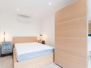 1 dormitorio con 1 cama y pared de madera en Appartement Fleury-Saint-Pierre-la-Mer, 3 pièces, 5 personnes - FR-1-409-204, en Fleury