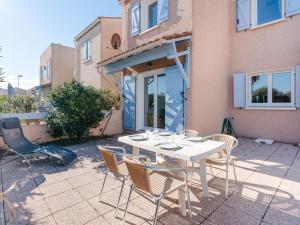 un tavolo bianco e sedie di fronte a una casa di Pavillon Confortable avec Piscine, Terrasse et Parking Privé - FR-1-409-220 a Fleury