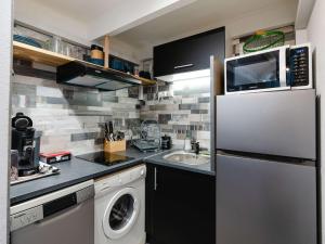 uma cozinha com um frigorífico e uma máquina de lavar roupa em Appartement Narbonne, 2 pièces, 6 personnes - FR-1-409-243 em Narbona