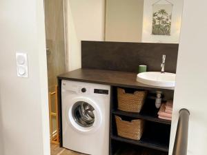 een badkamer met een wasmachine en een wastafel bij Gîte Tours, 2 pièces, 2 personnes - FR-1-381-554 in Tours