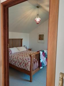 um quarto com uma cama e um lustre em The Loft at The Last Straw em Nelson