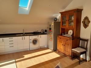 a kitchen with a refrigerator and a washing machine at The Loft at The Last Straw in Nelson