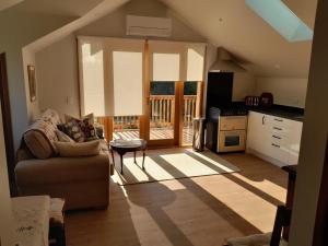 a living room with a couch and a kitchen at The Loft at The Last Straw in Nelson
