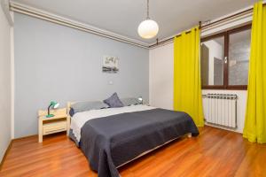 - une chambre avec un lit et des rideaux jaunes dans l'établissement Apartments with a parking space Rabac, Labin - 19055, à Rabac