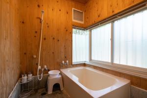 S-villa Nasu 8th في ناسو: حمام مع حوض كبير ونافذة