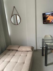 sala de estar con sofá blanco y espejo en Apartamento novo no Flamengo, en Río de Janeiro
