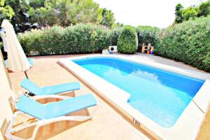 ベニッサにあるPaula - holiday home with private swimming pool in Benissaのラウンジチェア2脚とスイミングプール1つが備わります。
