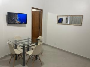 comedor con mesa de cristal y sillas en Apartamento novo no Flamengo, en Río de Janeiro
