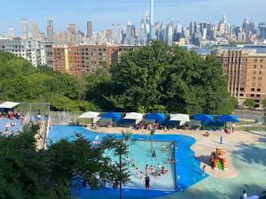 a large swimming pool with a city in the background at West NewYork NJ Cozy 2bed apt backyard to stay in West New York